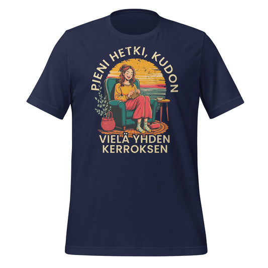 Sininen t-paita, jossa on kutoja nojatuolissa, teksti 'Pieni hetki, kudon vielä yhden kerroksen'. Retro tyylinen design, joka on hyvä lahjaidea kutojille.