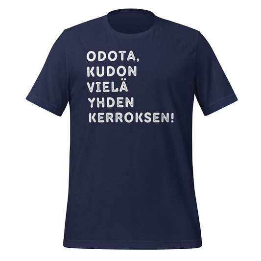 Sininen t-paita, jossa lukee 'Odota, kudon vielä yhden kerroksen' valkoisella tekstillä. Lahjaidea kutomisen ystävälle.